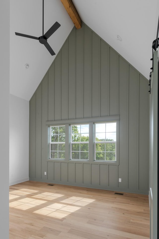 bonus room featuring a wealth of natural light, light wood-type flooring, beam ceiling, and visible vents