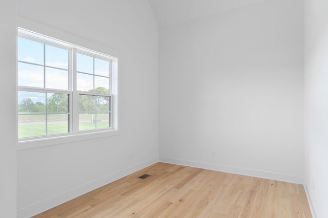 unfurnished room with wood finished floors, visible vents, and baseboards