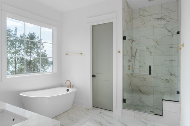 bathroom with a freestanding bath, marble finish floor, a marble finish shower, and a healthy amount of sunlight