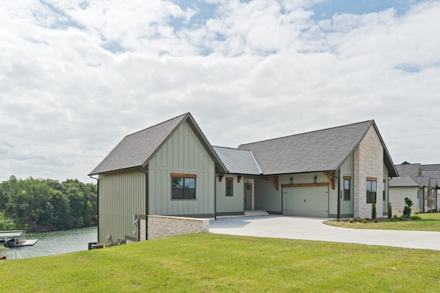 modern farmhouse style home with driveway, a garage, a water view, board and batten siding, and a front yard