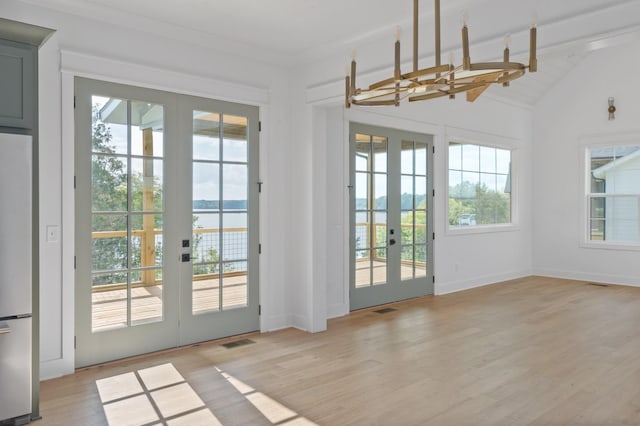 entryway with lofted ceiling, light wood finished floors, visible vents, and french doors