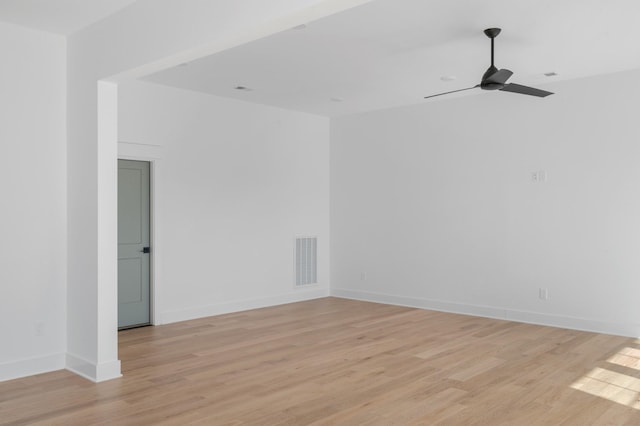 empty room with a ceiling fan, baseboards, visible vents, and light wood finished floors