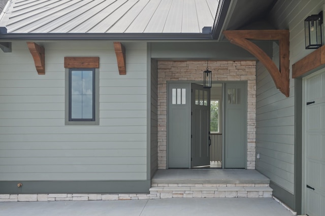 property entrance featuring metal roof, stone siding, a standing seam roof, and covered porch