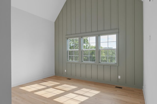 additional living space with high vaulted ceiling, visible vents, and light wood finished floors