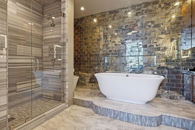 full bath with marble finish floor, a shower stall, and a freestanding bath