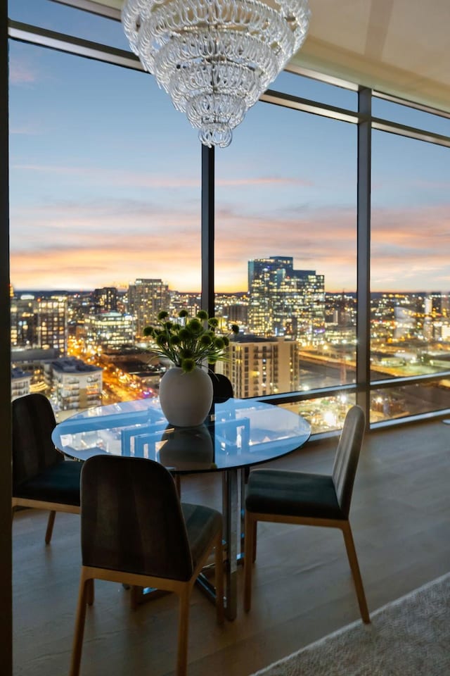 dining area featuring floor to ceiling windows, an inviting chandelier, and a city view