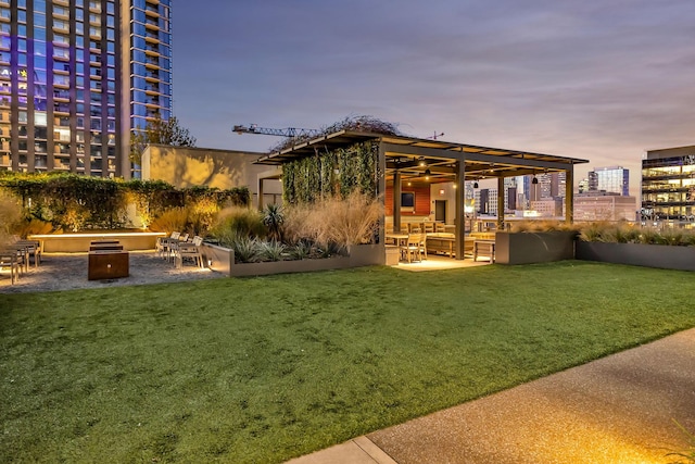 rear view of house featuring a yard, a patio, and an outdoor fire pit