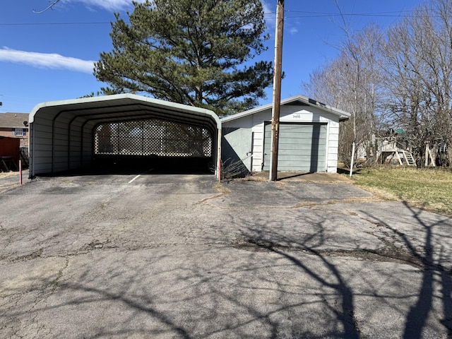 garage with driveway and a detached carport