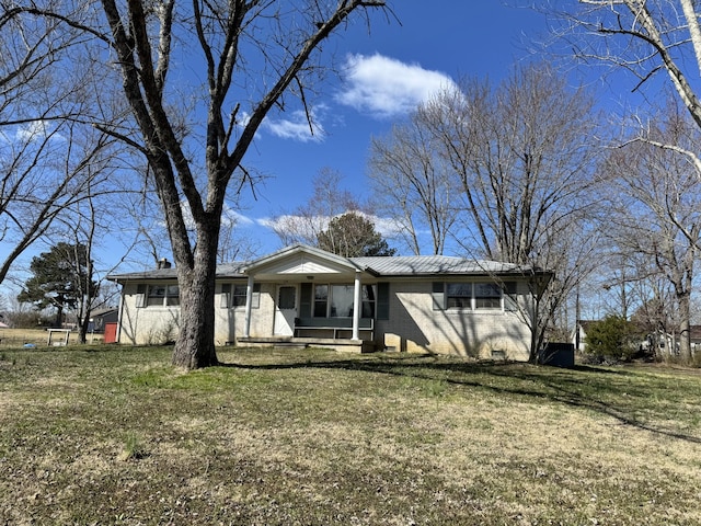 view of front of home featuring a porch, a front lawn, and brick siding