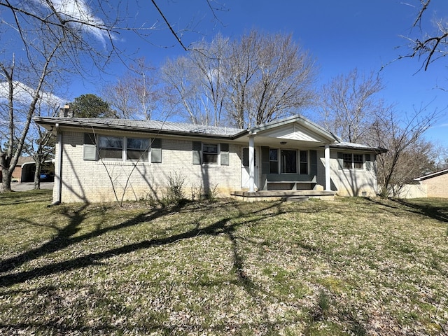 view of front of home featuring a front lawn, a porch, and brick siding