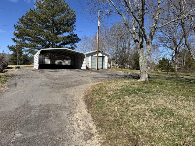 view of side of property with a carport and aphalt driveway