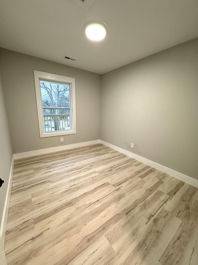 unfurnished room with light wood-style floors, baseboards, and visible vents