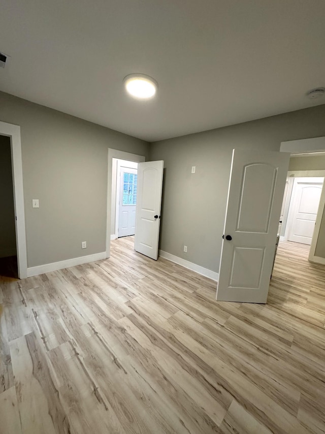 interior space with visible vents, light wood finished floors, and baseboards