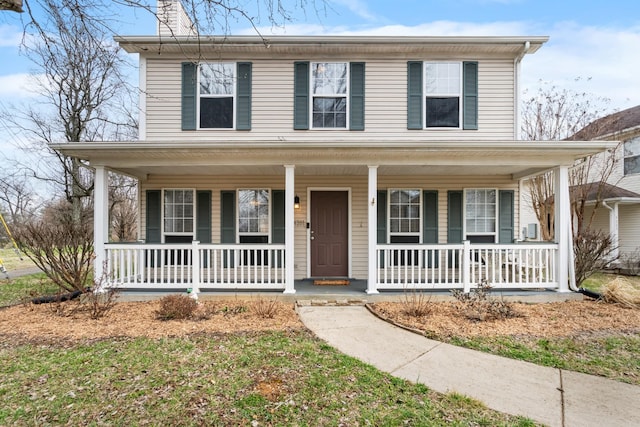 view of front of home featuring a chimney and a porch