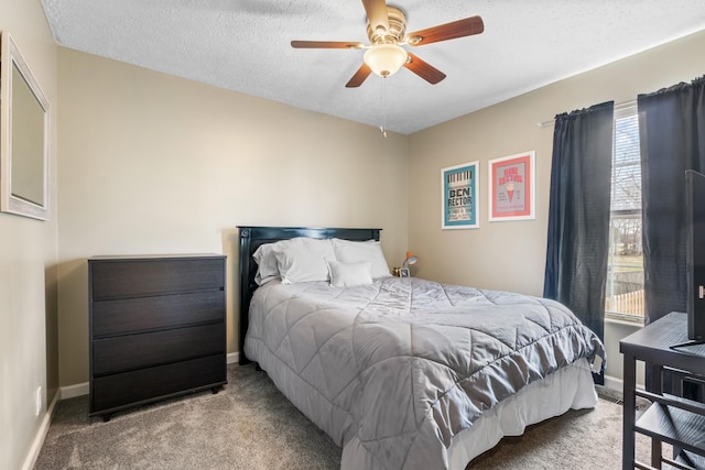 carpeted bedroom with ceiling fan, baseboards, and a textured ceiling