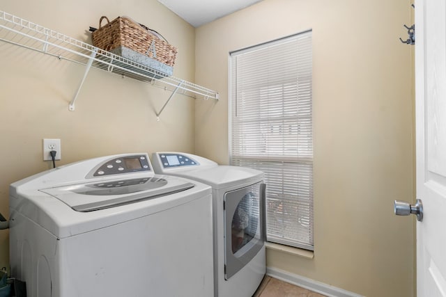 washroom featuring laundry area, light tile patterned flooring, and washing machine and clothes dryer