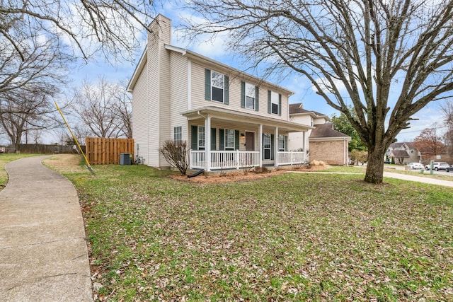 view of front of home featuring a chimney, covered porch, a front yard, central AC, and fence