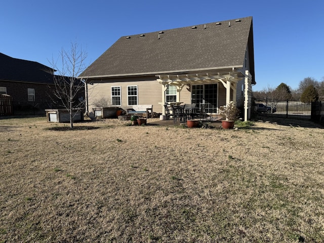 rear view of house featuring fence, roof with shingles, a lawn, a pergola, and a patio