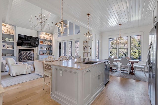 kitchen featuring a chandelier, appliances with stainless steel finishes, light wood finished floors, and a sink