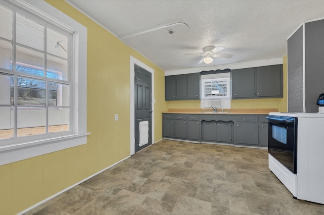 kitchen with gray cabinets, electric range, a sink, a textured ceiling, and ceiling fan