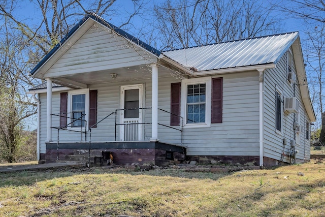 bungalow-style house featuring metal roof, a front lawn, and a porch