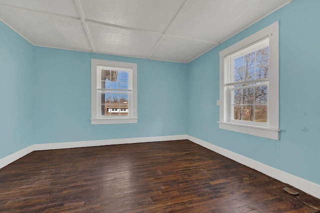 unfurnished room featuring baseboards and wood finished floors