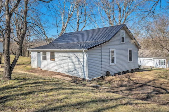 view of side of property with metal roof and a yard