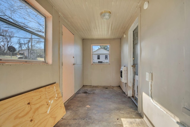 interior space with unfinished concrete floors and heating unit