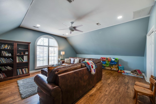 living room featuring visible vents, vaulted ceiling, and wood finished floors