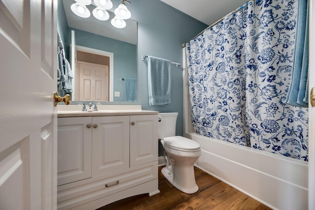 bathroom with toilet, shower / bath combo with shower curtain, wood finished floors, and vanity