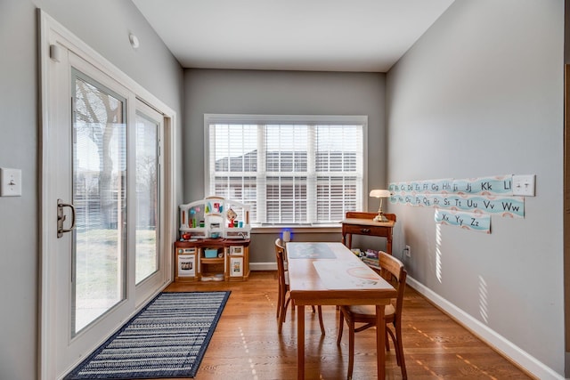 dining area with baseboards and wood finished floors