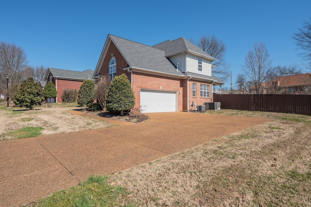 view of side of home with brick siding, roof with shingles, central AC, fence, and driveway