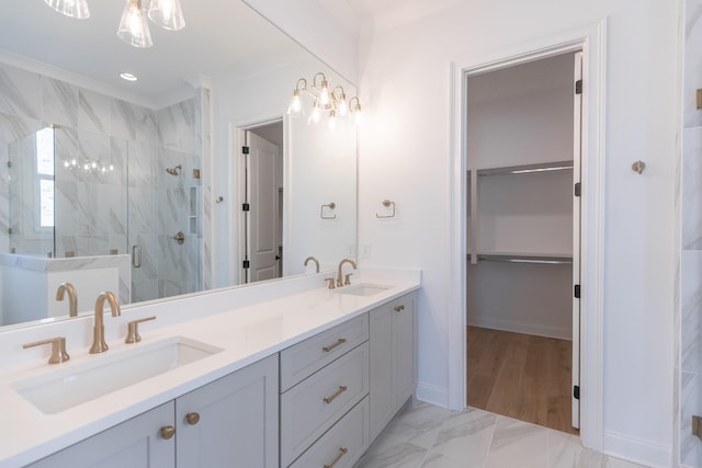 full bath featuring marble finish floor, a sink, a shower stall, and double vanity