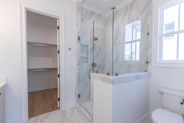 bathroom with a marble finish shower, toilet, marble finish floor, a spacious closet, and vanity