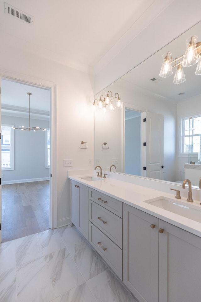 full bath featuring marble finish floor, double vanity, a sink, and visible vents