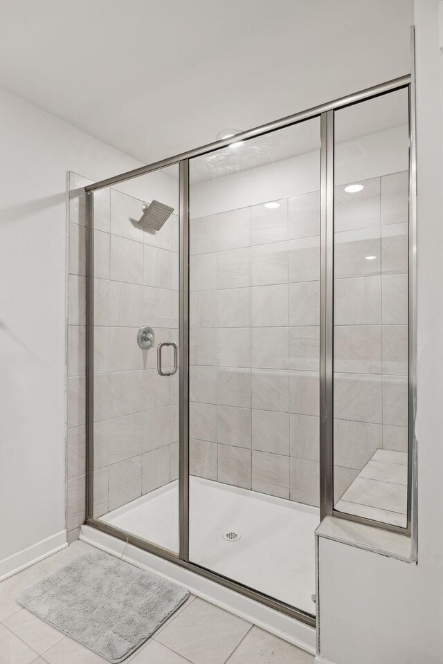 bathroom with a shower stall and tile patterned floors