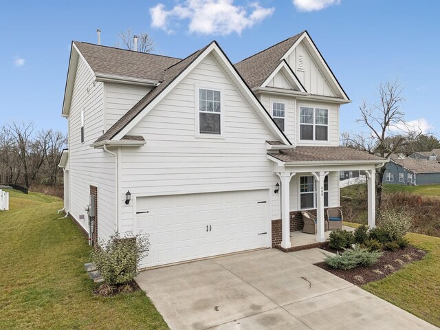 traditional-style house with driveway, a porch, an attached garage, a front lawn, and board and batten siding