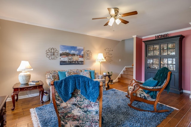 living area featuring stairs, wood finished floors, baseboards, and ornamental molding