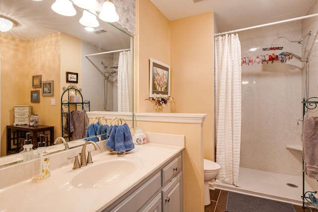 full bath with a shower with curtain, toilet, vanity, and visible vents