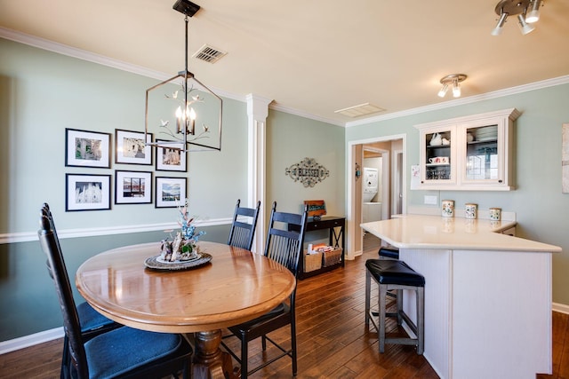 dining room with visible vents, dark wood-type flooring, and ornamental molding