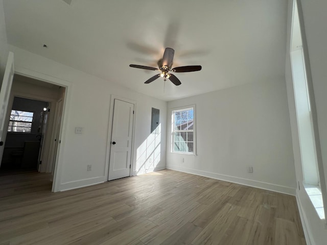 spare room featuring light wood-style flooring, baseboards, and ceiling fan