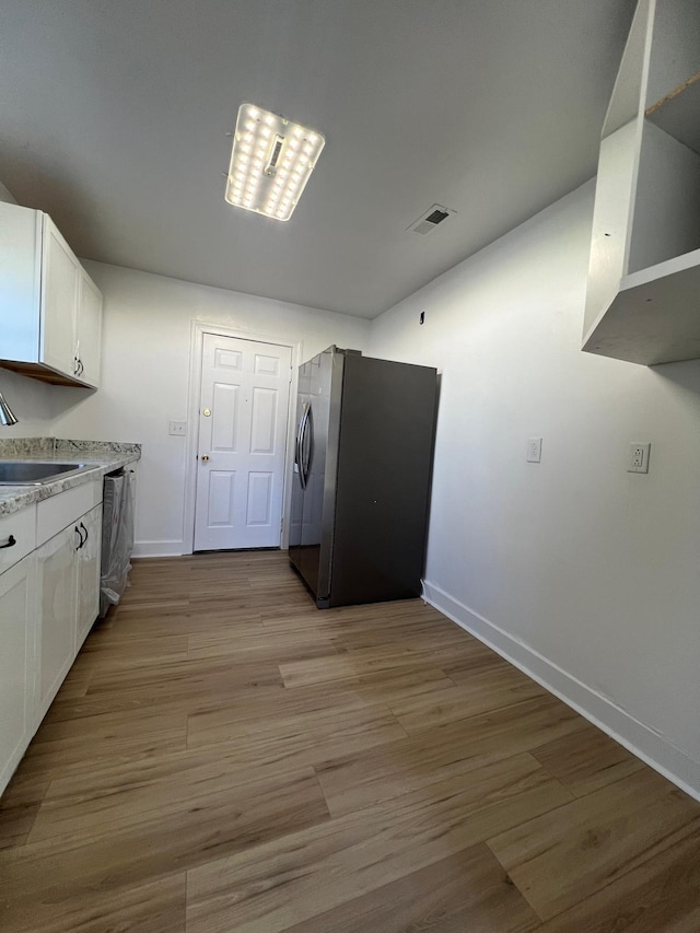 kitchen featuring white cabinets, appliances with stainless steel finishes, and light wood-style floors