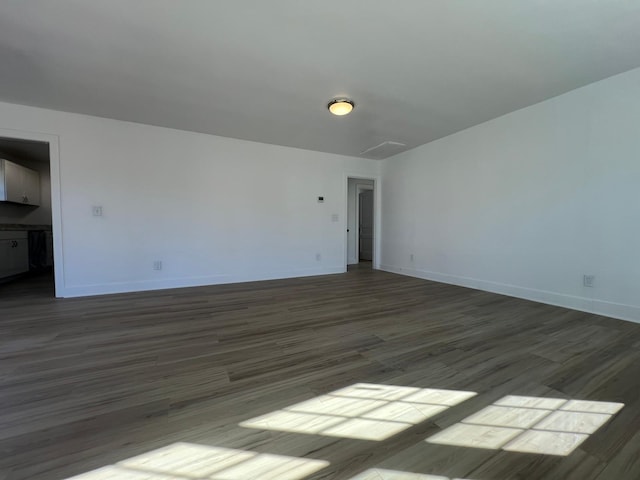 unfurnished room featuring baseboards and dark wood-style flooring