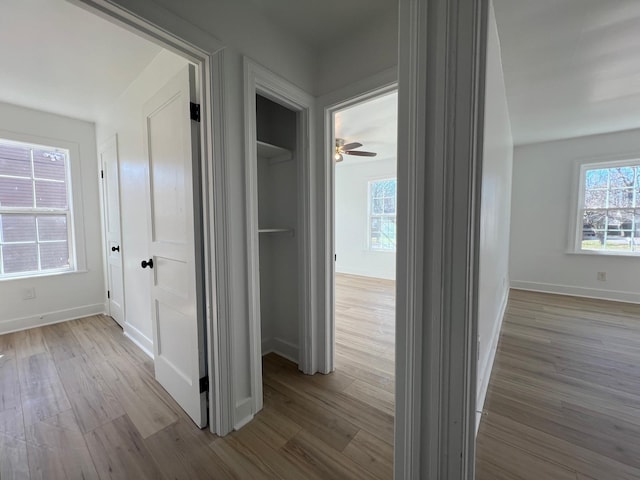 hallway with wood finished floors and baseboards