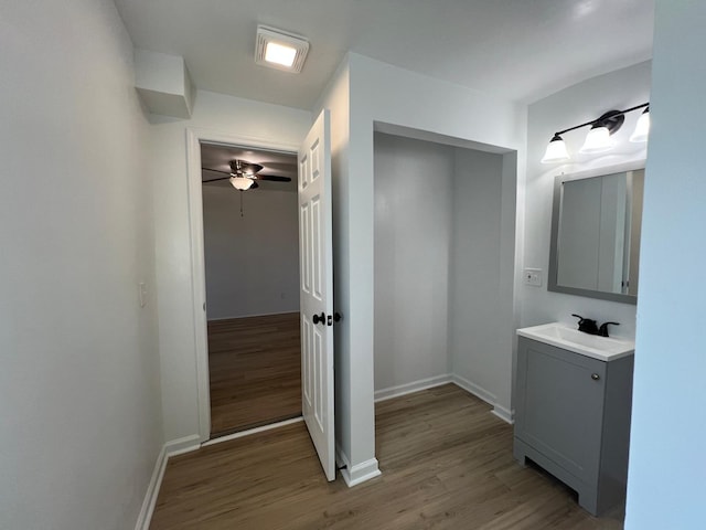 bathroom with vanity, a ceiling fan, baseboards, and wood finished floors