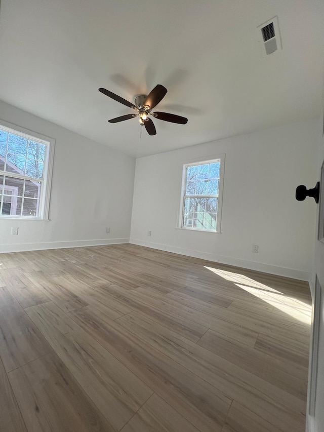 unfurnished room with visible vents, baseboards, and wood finished floors