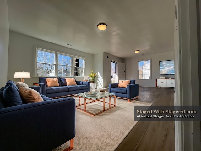 living area featuring visible vents and wood finished floors