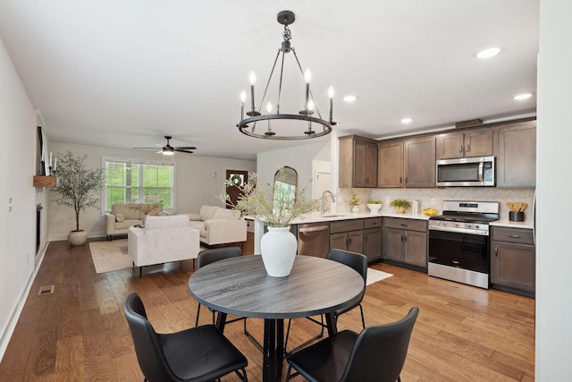 962 Belmont Rd, Clarksville, TN 37040 - kitchen with stainless steel appliances, light countertops, decorative backsplash, ceiling fan, and light wood-style floors