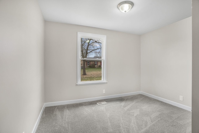 carpeted empty room featuring baseboards and visible vents