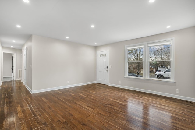 unfurnished room with baseboards, dark wood finished floors, and recessed lighting